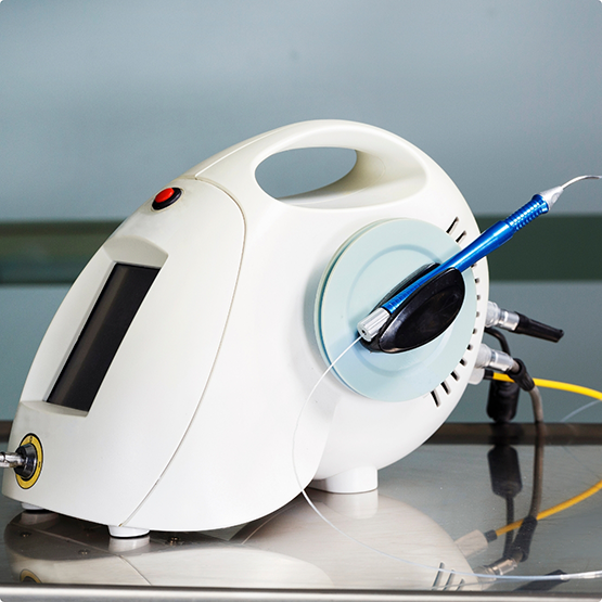 Pen-like dental laser device attached to a larger device with a screen