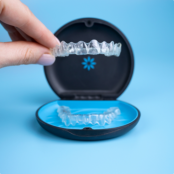 Person placing an Invisalign aligner in its storage case