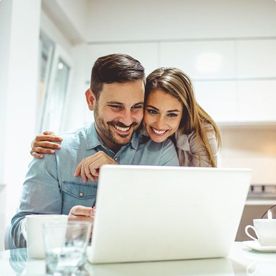 Smiling man and woman looking at a laptop together