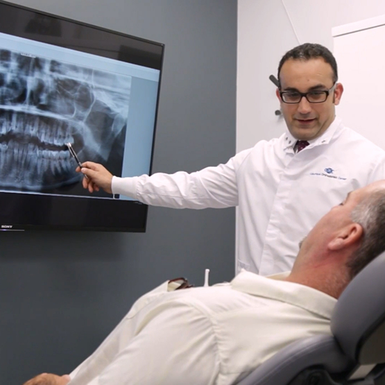Orthodontist showing a patient x-rays of his teeth