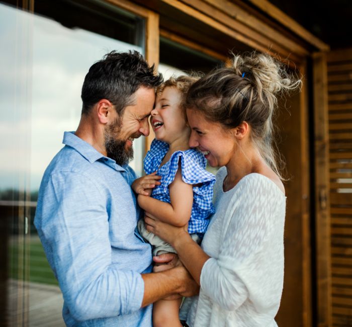 Laughing parents holding their toddler