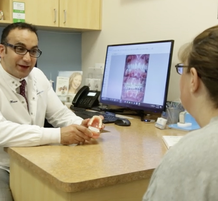 Columbus orthodontist Doctor Amin Mason showing a model of the teeth to a patient