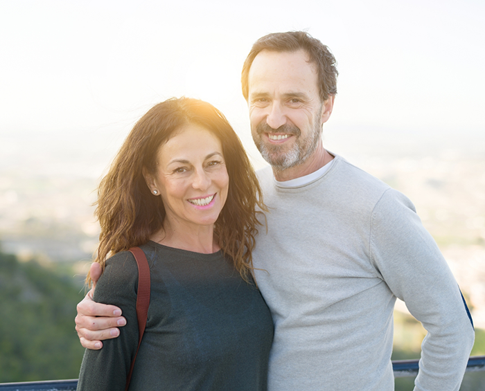 Man and woman smiling outdoors in the late afternoon sun