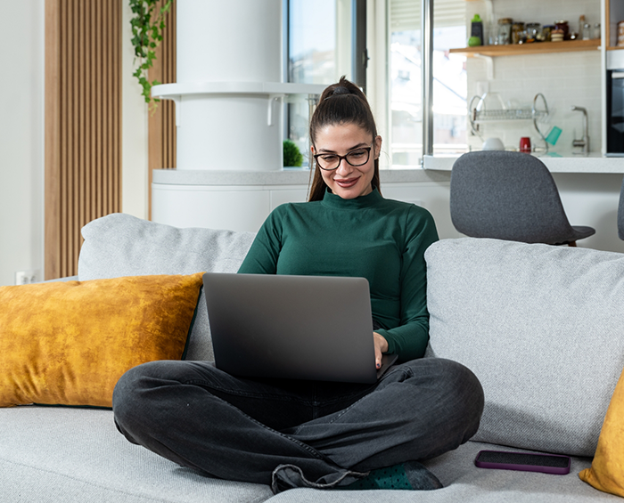 Woman on a couch using a laptop