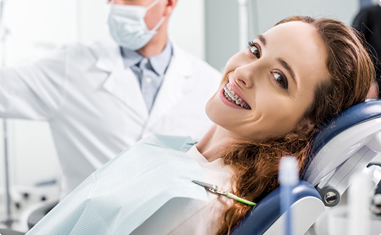 Smiling woman with braces in the treatment chair