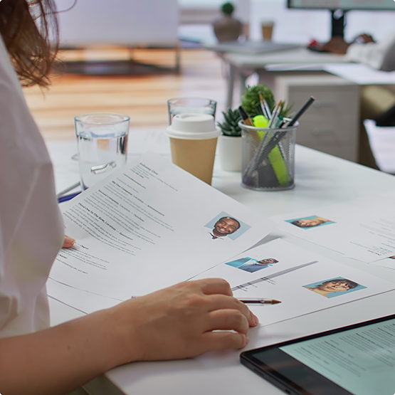 Person looking through several resumes
