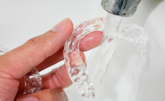 Person cleaning Invisalign in the sink