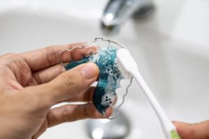 Person using brush to clean their retainer